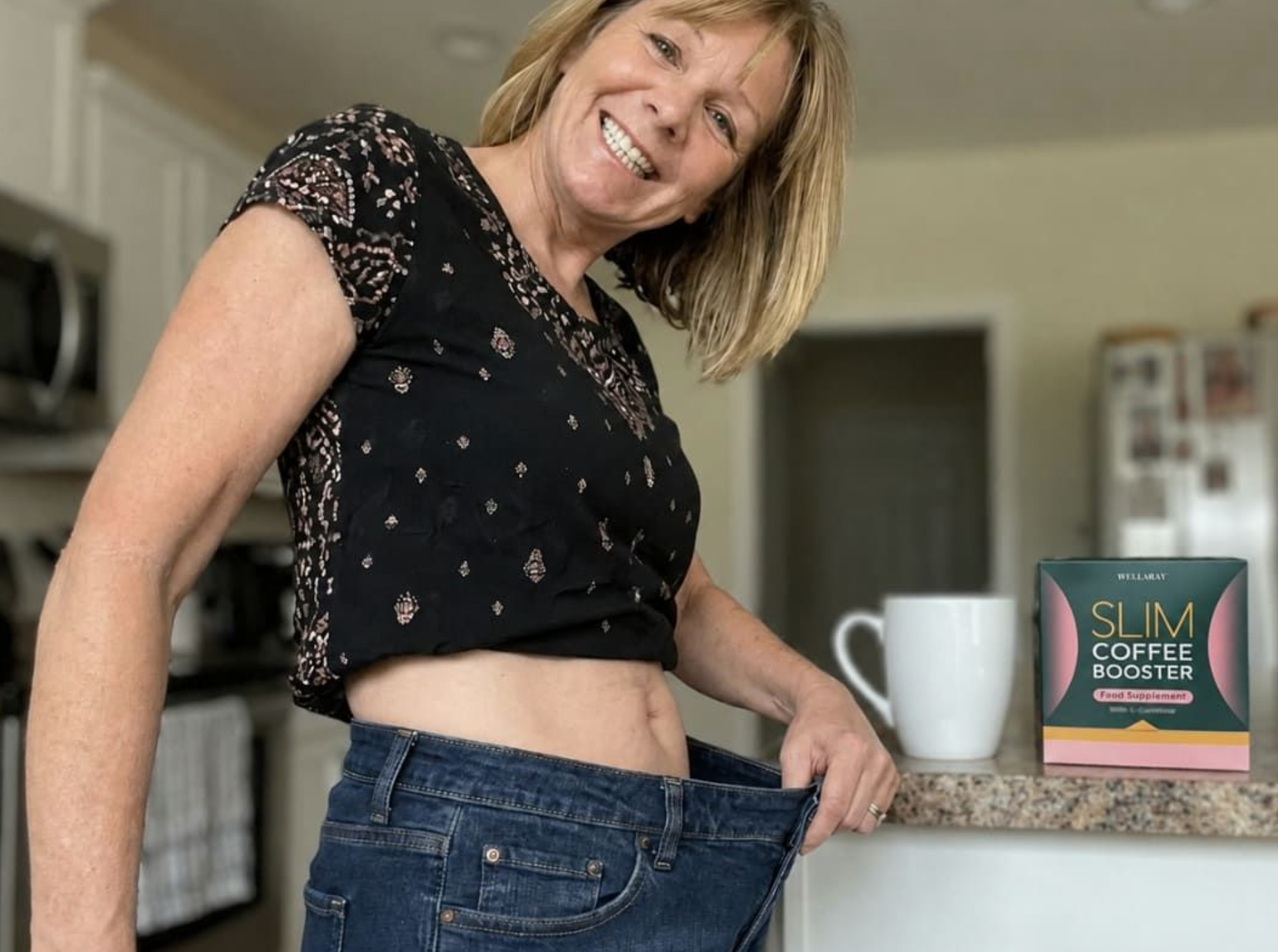 A Wellaray Diet customer holding out loose-fitting jeans next to her coffee and product box